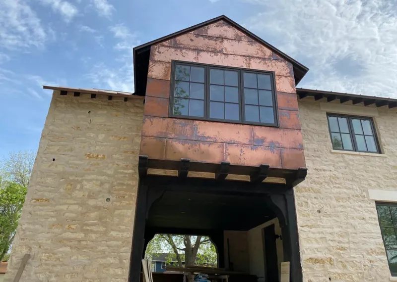 Copper metal panel facade on a stone building for Skylight Installation in Lyons