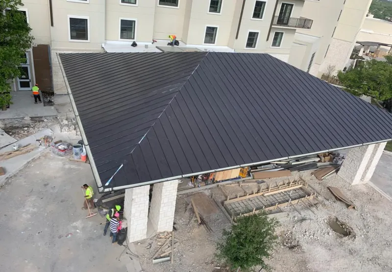 Metal roofing installation team working on a commercial building in Lyons